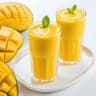 Fresh Mango Smoothie in Glass with Tropical Fruits